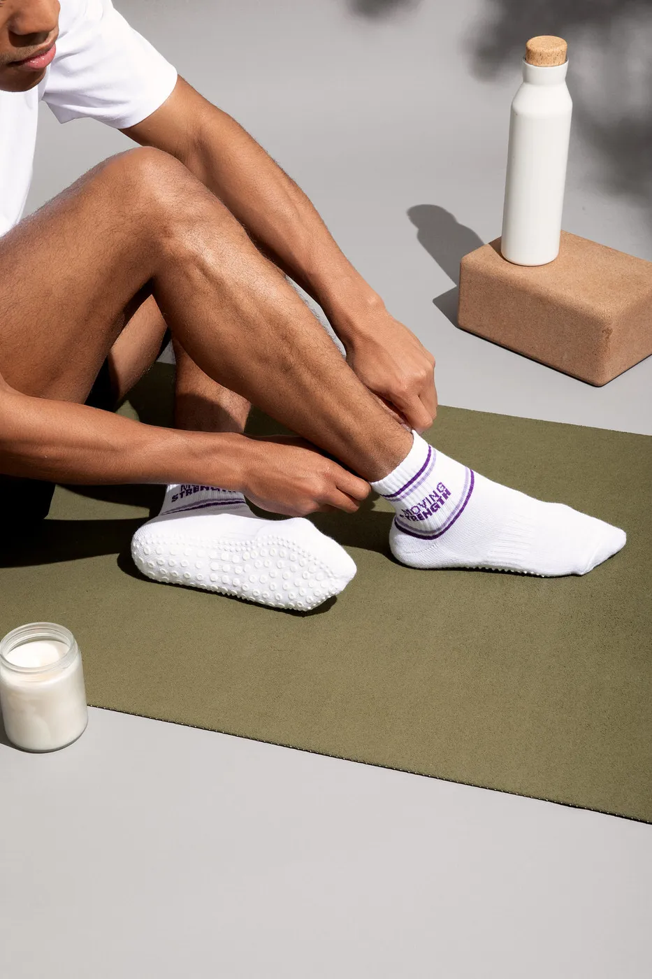 man putting on socks on yoga mat
